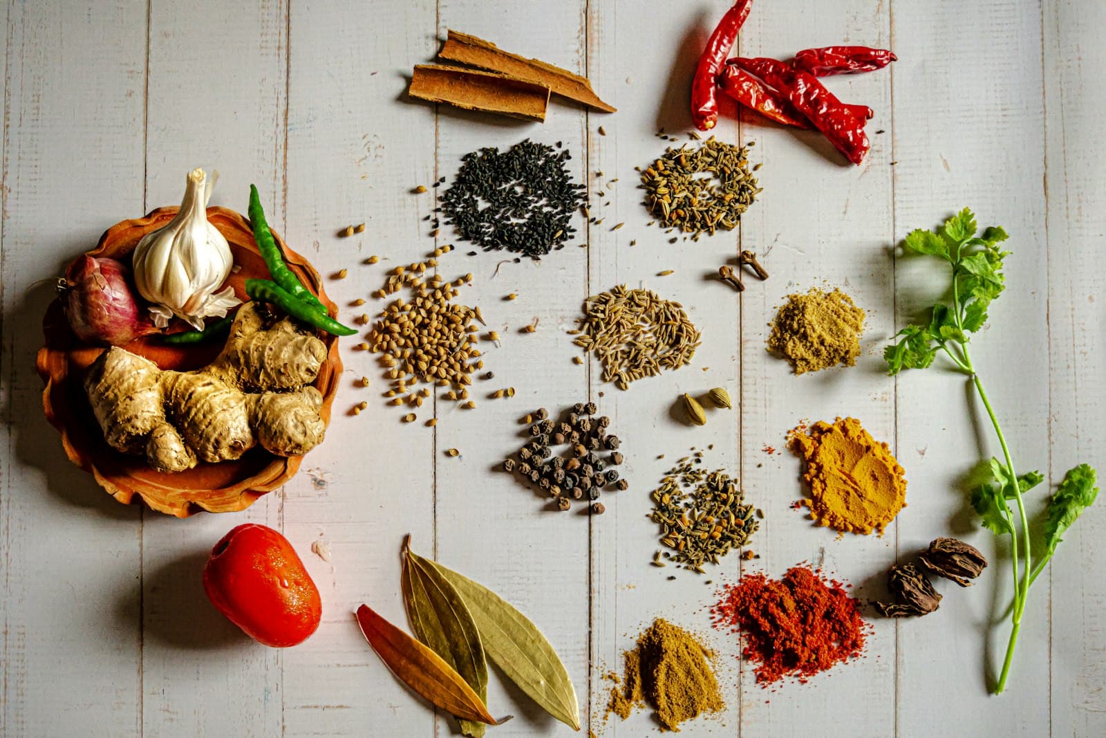 Whole and ground Indian spices laid out on a table